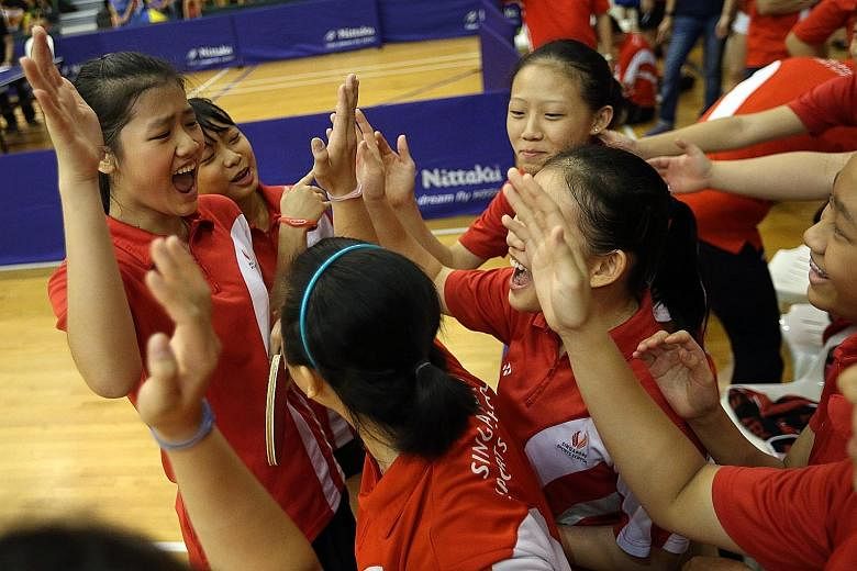 Above: SSP paddlers (from left) Wong Xin Ru and Lew Yen Lin celebrating with team-mates after winning the crucial fourth match in the B girls' final. Left: An elated Ryan Goh feeling on top of the world after RI won the A boys' final but he later ear