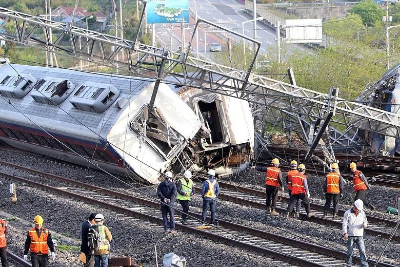 Rescue workers at the site where a train derailed in Yeosu, South Korea, yesterday. The overnight train, which left Seoul late on Thursday, derailed at 3.40am, killing an engineer and injuring eight others, railway operator Korail said. The accident 