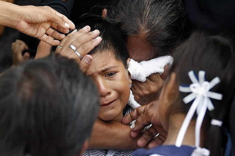 A woman trying to console an eight-year-old boy whose mother died in the April 16 earthquake, during her funeral in Manta, Ecuador, on Thursday.