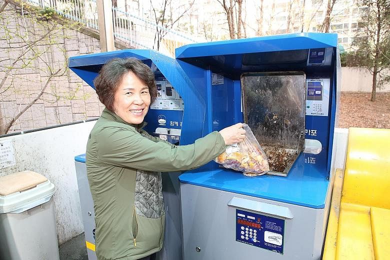 South Korean housewife Cho Sung Ja using an RFID food waste disposal system that is able to weigh how much trash each household generates and bill it accordingly. She lives in a three-bedroom apartment with her husband and son in Mapo, a mid-sized di