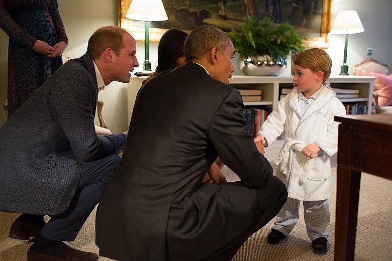 Left: A photo released by Kensington Palace on Friday shows Britain's Prince George of Cambridge (at right) meeting US President Barack Obama and First Lady Michelle Obama (partly hidden) at Kensington Palace in London, while the young royal's father