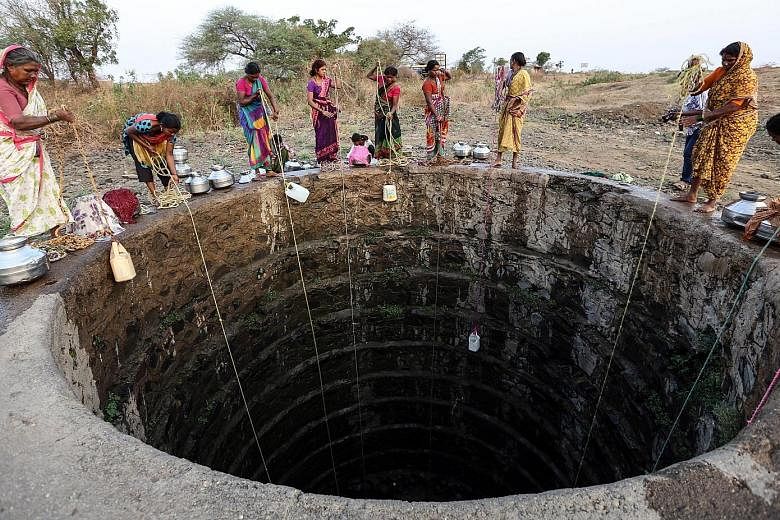 Villagers trying to draw water from an almost dried-up well (above) at Rasegaon in Maharashtra. Elsewhere in the state, workers at a railway station in Miraj city (left) load water onto a train bound for drought-hit areas in and around Latur district