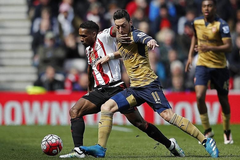 Sunderland striker Jermain Defoe vies for the ball with Arsenal's Mesut Oezil. The goal-less draw leaves the Black Cats with the finest of breathing spaces as they climbed out of the drop zone thanks to their goal difference.