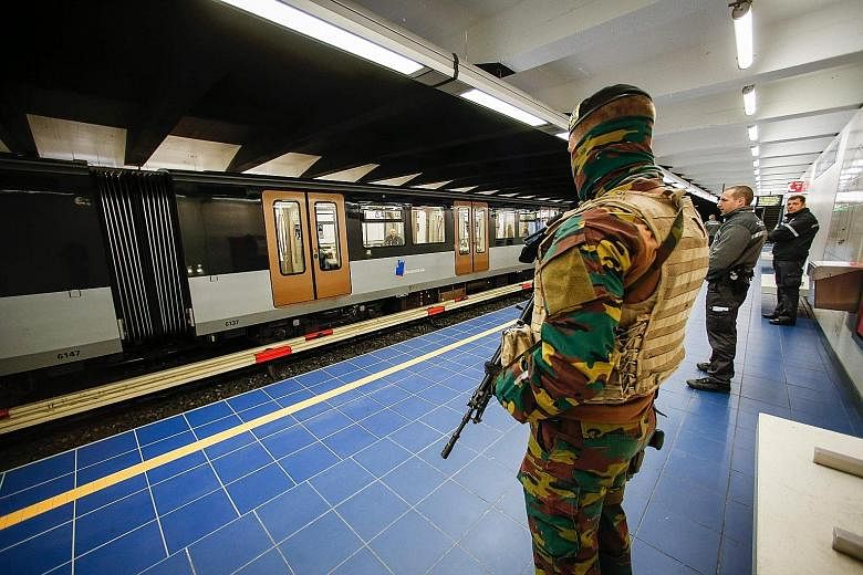 A Belgian soldier standing guard as a train arrives at the Maelbeek metro station in Brussels yesterday. It was the station's first day of operation since being closed following the terror attacks in the city on March 22. The station and the city's a