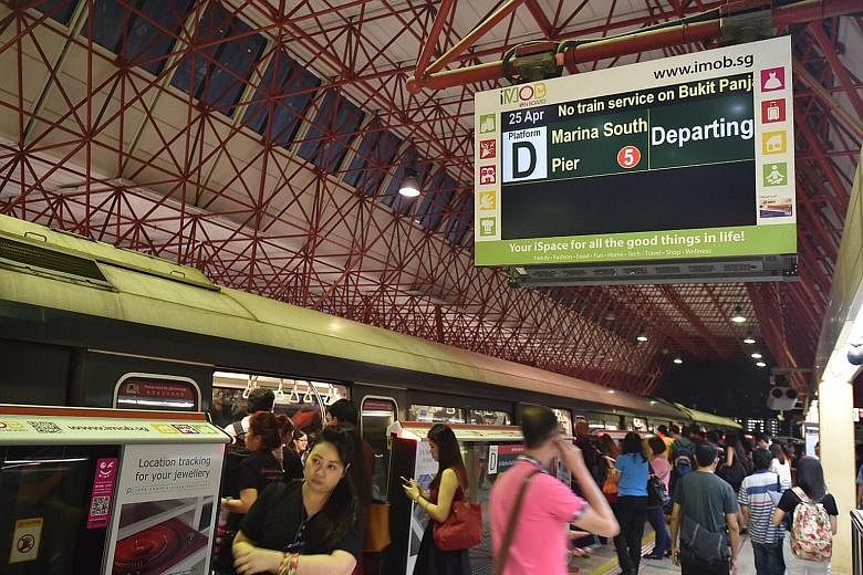 Commuters on the platform at Jurong East MRT station last night. The screen shows a notice about the disruption in train service. The Tiong Bahru MRT station with its emergency lights on as many passengers waited in the train for service to resume.
