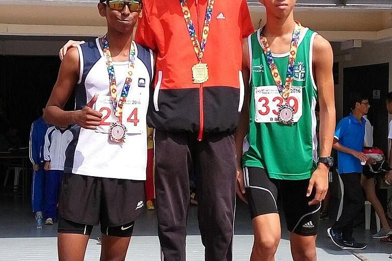 Fang Yiyang (centre) of Commonwealth Secondary School stands with St Joseph's Institution's Dave Tung and Guangyang Secondary School's Ruben Loganathan on the podium after winning the 2000m steeplechase.