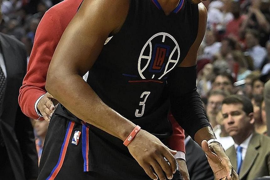Above: Los Angeles Clippers guard Chris Paul walks off the court after injuring his hand in the third quarter against the Portland Trail Blazers on Monday. The Clippers are 3-5 this season in games without their talisman. Right: Portland guard Damian