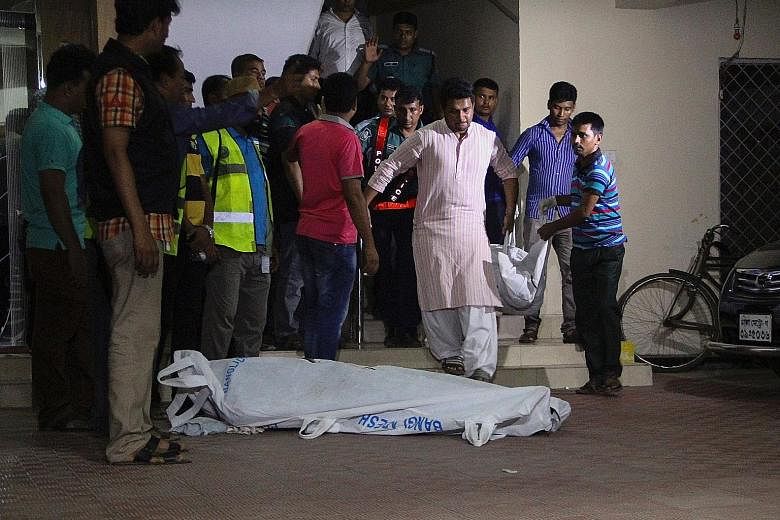 The bodies of the two murdered gay rights activists being taken away from an apartment building in Dhaka on Monday. There has been a series of attacks on minorities in the country recently.