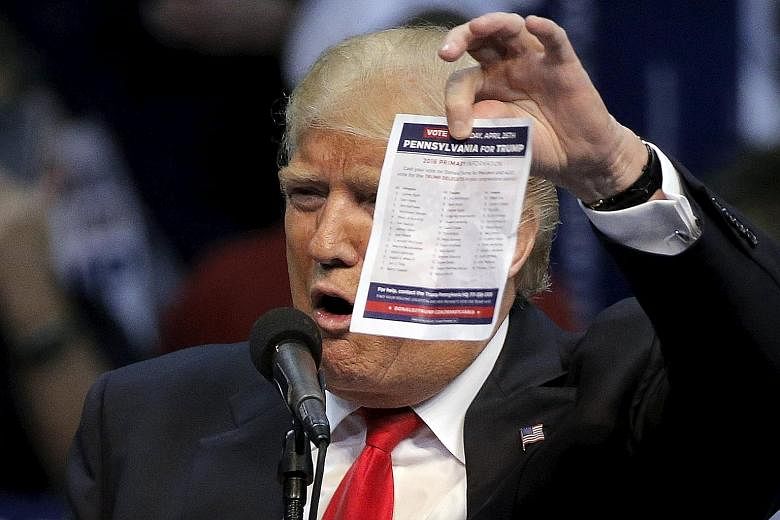 Republican front runner Donald Trump holding the delegates list for the Pennsylvania state primary during a rally in the state on Monday. The New York tycoon says the deal between his two remaining challengers "shows how weak they are".