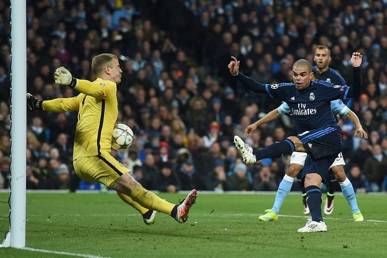 Manchester City's Joe Hart (left) shows he can stomach any challenge as he makes an unconventional save against Real's Pepe during the Champions League semi-final first leg 0-0 draw on Tuesday. 