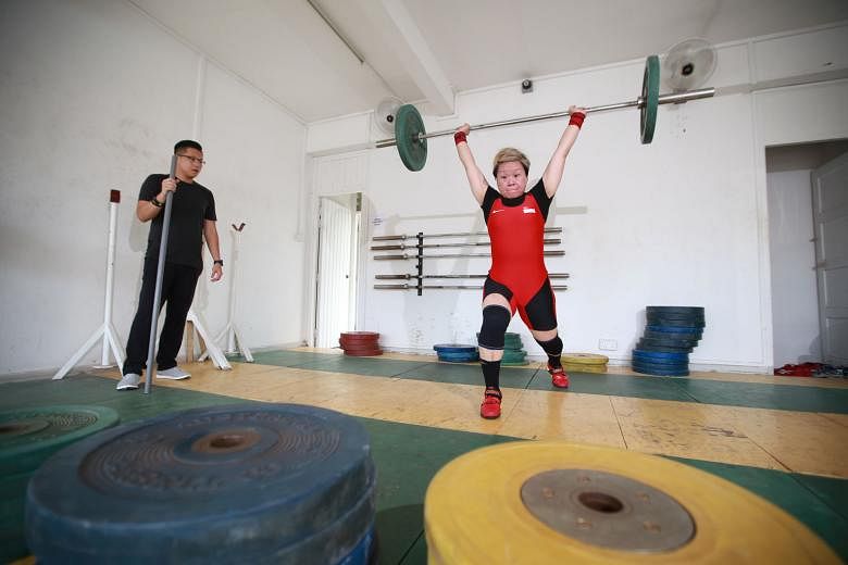 World Masters champion Tan Lay Sang (in red) training at the Singapore Weightlifting Federation as her coach Wu Chuan Fu looks on. The trailblazer wants to create a Masters division within the SWF. 