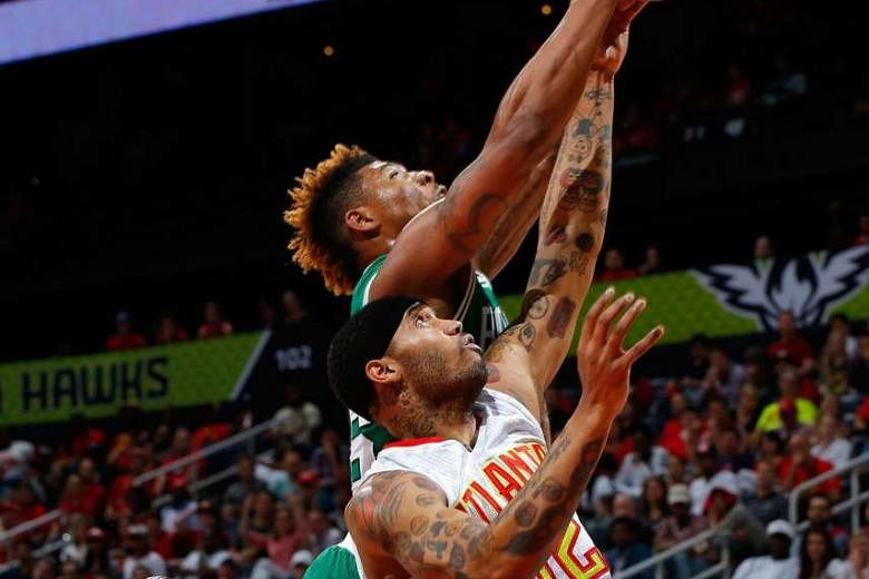 Celtics guard Marcus Smart grabs a rebound against Hawks forward Mike Scott in Atlanta's 110-83 win on Tuesday. Scott came off the bench to lead all scorers with 17 points. 