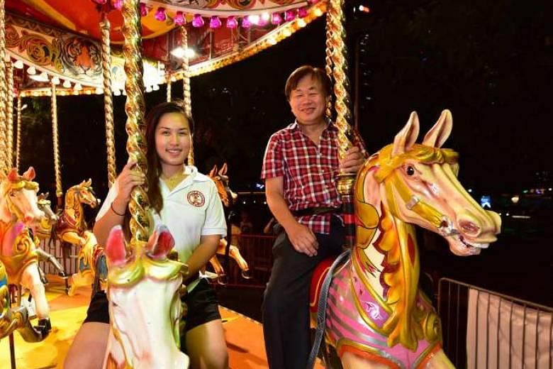 Mr Lee, better known as Uncle Ringo, on a horse carousel with his daughter Joyce, who is the company's sales and marketing manager. Mr Lee started the funfair in 1984, the same year his daughter was born.