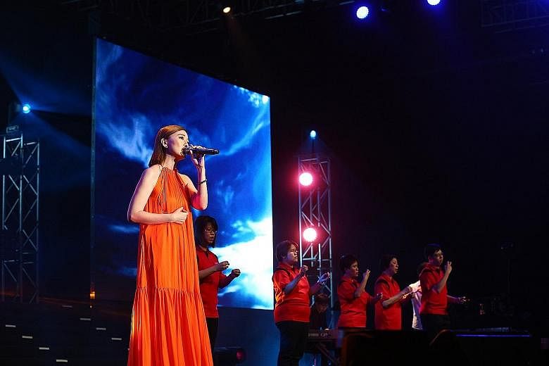 Singer Joi Chua performing with members of the Touch Silent Club at the Care & Share Thank You concert at Singapore Expo yesterday. The movement exceeded expectations in the amount raised.