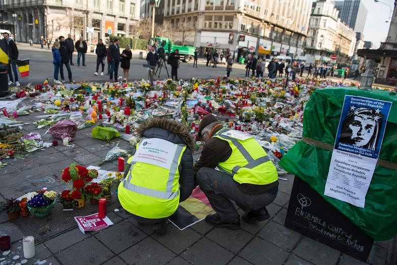 Members of the archives of the city of Brussels collecting messages left at the Brussels Stock Exchange in tribute to the victims of the March 22 terrorist attacks, to preserve them. ISIS claimed responsibility for the massacre. The writer says that in th