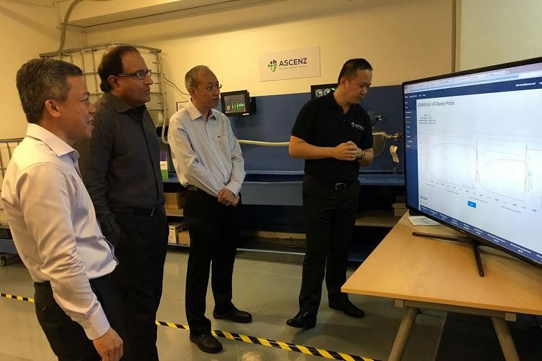 (From left) Mr Chia, Ascenz chief executive; Mr Iswaran, Trade and Industry Minister; Mr Sia, Ascenz chief technology officer; and Mr Bernard Siah, Ascenz product development manager, viewing a demonstration of Ascenz's proprietary monitoring system yeste
