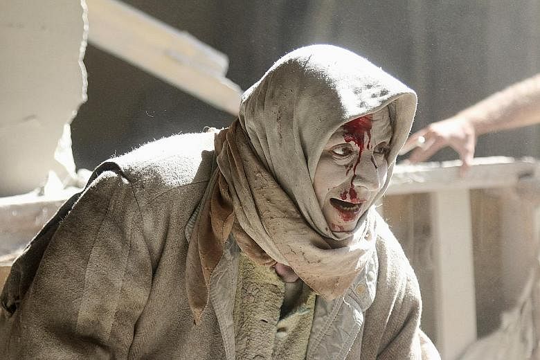 An injured woman at a site hit by air strikes in the rebel-held area of Old Aleppo in Syria on Thursday. More than 200 civilians have been killed in Aleppo over the past week in renewed violence that has shattered a partial truce in Syria's civil war