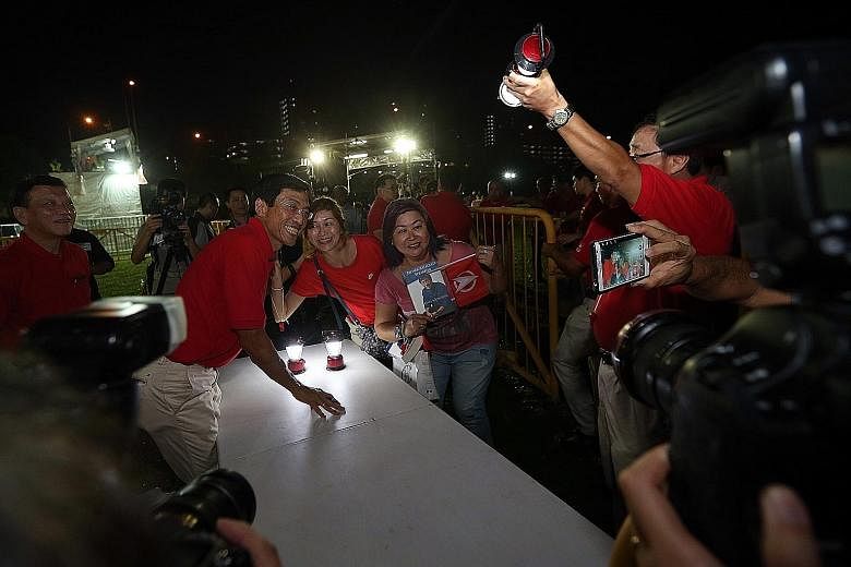 (Below) Dr Chee's supporters taking a picture with him last night at the field along Bukit Batok Industrial Park A, where he held his first rally of the campaign. In his speech, Dr Chee promised Bukit Batok residents that if he wins the by-election o