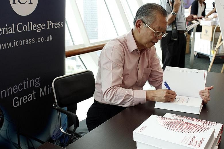 Mr Lim signing copies of his book - Winning With Honour In Relationships, Family, Organisations, Leadership, And Life - which is co-authored by his daughter Joanne.