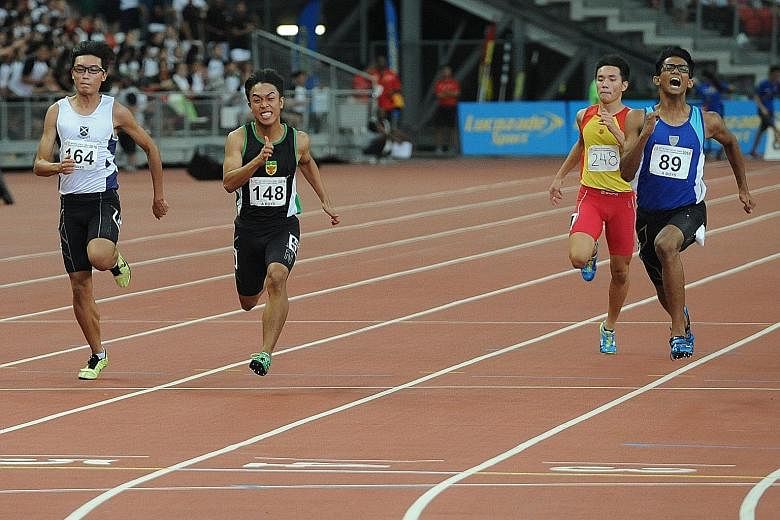 Shahmee Ruzain of Catholic Junior College (right) winning the A Division 100m yesterday. He won the 200m gold on Monday and helped CJC to a silver medal in the 4x100m relay.
