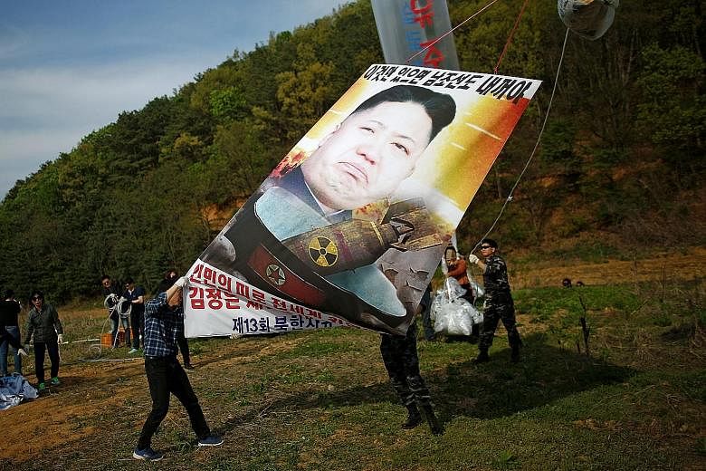 Activists near the demilitarised zone in Paju, South Korea, yesterday calling for the end of North Korean leader Kim Jong Un's reign. The secretive state is expected to conduct another nuclear test ahead of a party congress.