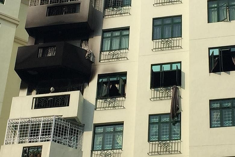 The smoke-blackened exterior of the condo unit at Hillview Green. One of the residents, Mr Timothy Ng, climbed down from the window of the seventh-floor unit to the floor below, after failing to open the main door. He went back up to open the door fr