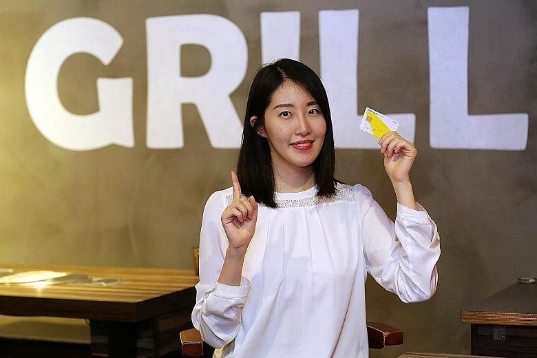 Ms Kim holding the debit card she uses for daily expenses. Only about 20 per cent of all payments in South Korea are made with cash, as credit cards, debit cards and T-money become more popular.