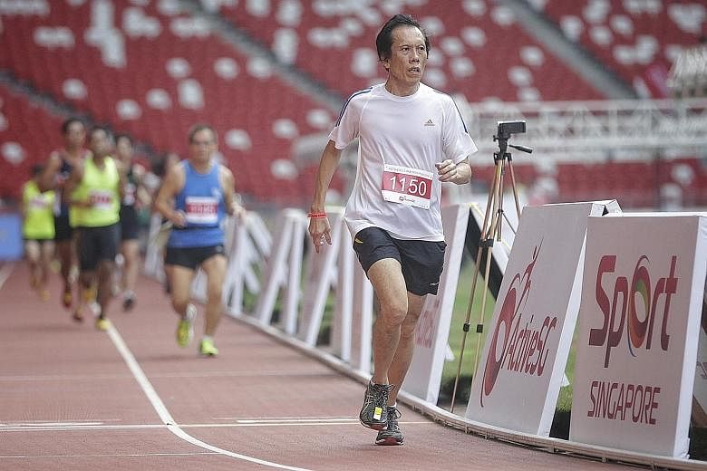 Bernard Chan (foreground) running at the National Stadium for the first time. The 64-year-old, who used to run at the old National Stadium, got the chance with other members of the public to run at the Sports Hub yesterday thanks to the ActiveSG Athl