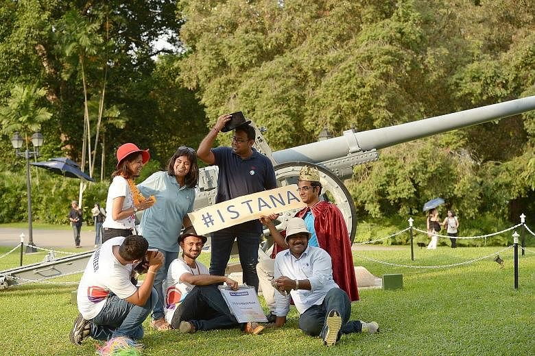 Staff from Cognizant Technology Solutions helping visitors snap a wefie in front of the 105mm Japanese cannon at the Istana during its May Day open house yesterday. The IT services firm was raising funds for the President's Challenge by running a pho