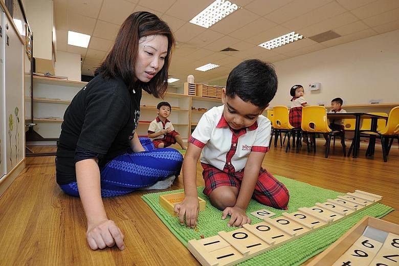 Senior teacher Pauline Yong guiding an N2 pupil at Brighton Montessori as he uses the Seguin board to learn about the ones and tens of two-digit numbers. The children move from doing something concrete with counting beads to the abstract of recognisi