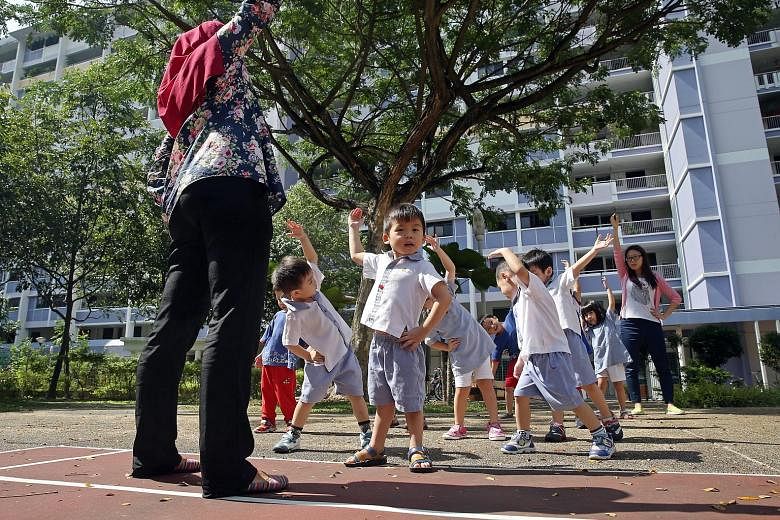 Tiny tots getting some stretching pointers from their teachers at PCF Sparkletots Preschool in Bedok North Road. Education experts say besides comparing prices when looking for a pre-school, parents may also want to observe the quality of interaction