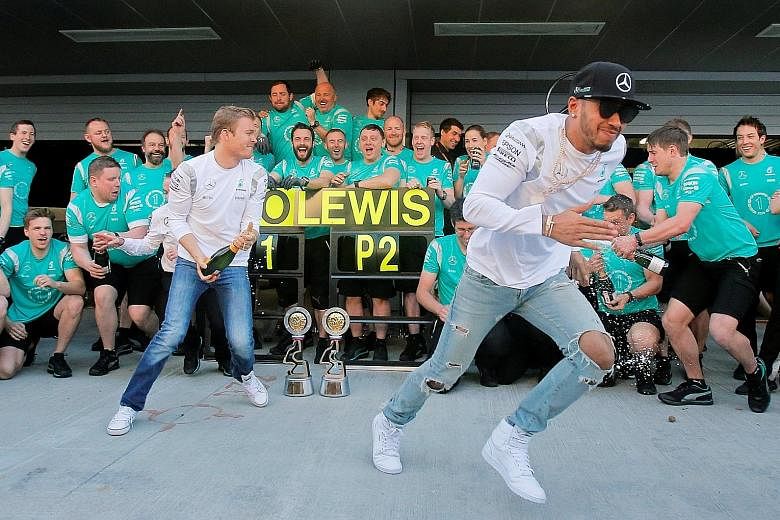 Mercedes drivers Nico Rosberg (left) and Lewis Hamilton celebrate a 1-2 finish at the Russian Grand Prix with their team.