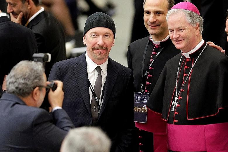U2 guitarist The Edge poses with Irish bishop Paul Tighe (far right) before listening to US Vice-President Joe Biden’s address at the Vatican.
