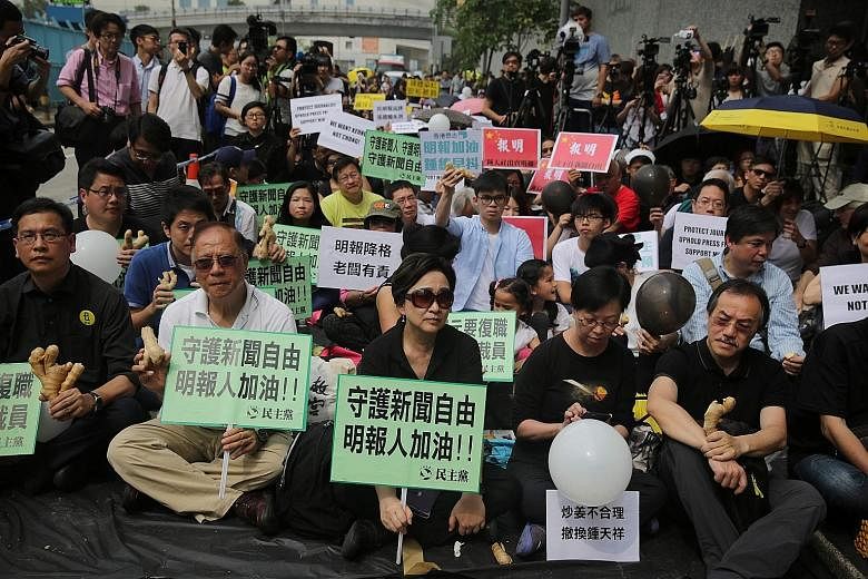 Protesters sitting outside Ming Pao's office in Hong Kong yesterday. In their hands were pieces of ginger - a pun on the surname of the paper's former No. 2 editor Keung Kwok Yuen, who was sacked last month.