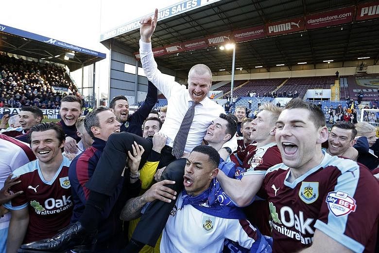 Burnley manager Sean Dyche celebrates a return to the Premier League with his players after their 1-0 win over Queens Park Rangers.