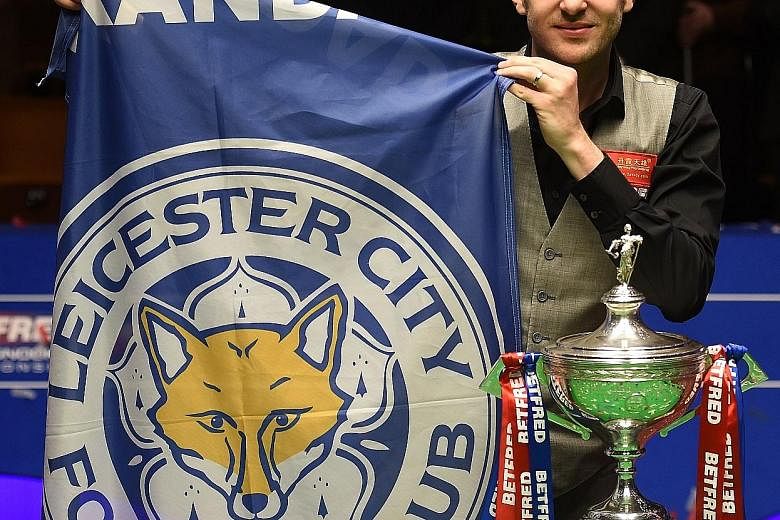 England's Mark Selby holding a Leicester City banner next to his trophy after beating China's Ding Junhui in the final of the World Snooker Championship at the Crucible Theatre in Sheffield.