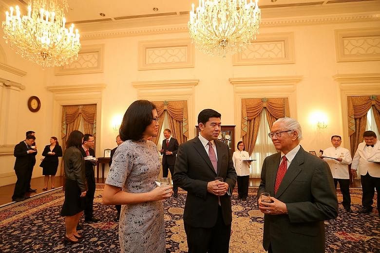 Mr Gabriel Lim, 40, and his wife, Sharon, chatting with President Tony Tan Keng Yam during a reception after Mr Lim was sworn in as Second Permanent Secretary (Ministry of Communications and Information) at the Istana yesterday. Mr Lim, a former prin