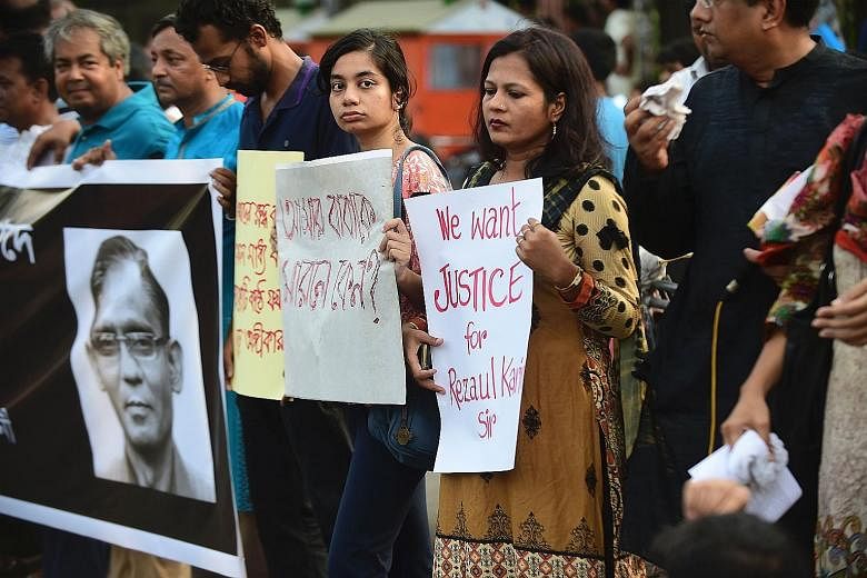 Protesters and former Rajshahi University students holding placards during a demonstration in Dhaka last Friday against the killing of English professor Rezaul Karim Siddique.