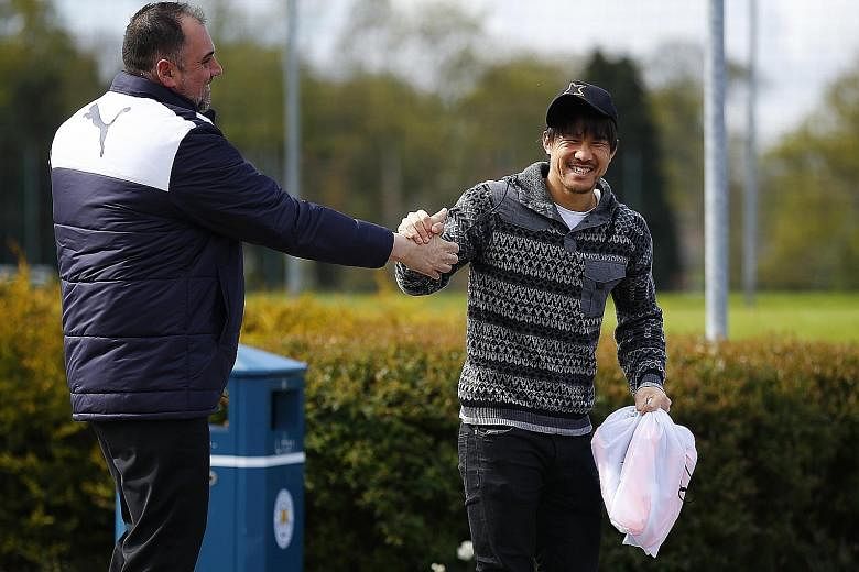 Leicester's Japanese striker Shinji Okazaki getting a congratulatory handshake from a fan as he arrived at the Foxes' training ground yesterday. His non-stop running has fit well with Leicester's counter-attacking style.