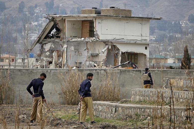 Policemen standing guard during 2012 demolition works at the Abbottabad compound (above) where Osama (left) was killed. The US Central Intelligence Agency marked the fifth anniversary of the May 2, 2011 raid by live-tweeting it (right), as if it was 