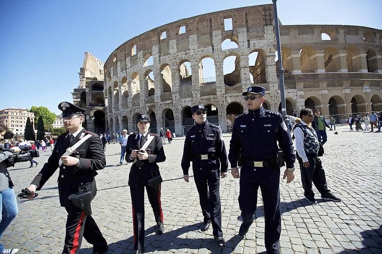Two Chinese police officers (right) and their Italian counterparts at the Colosseum in Rome on Monday. In the two-week trial that began yesterday, four units - each with one Chinese officer and one Italian officer - are posted to tourist hot spots in