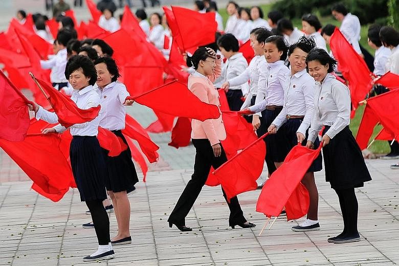 Girls on Wednesday practising dancing with red flags in central Pyongyang ahead of today's party congress. The event marks the political high point of Mr Kim's four-year rule.