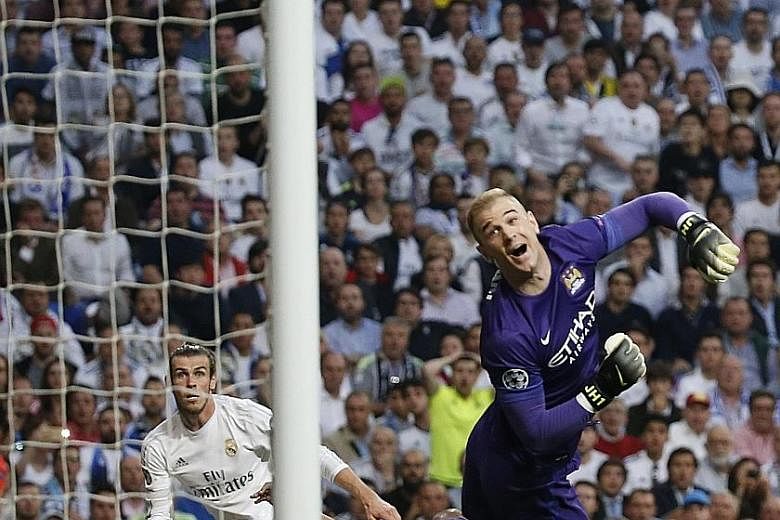 Real forward Gareth Bale's (left) shot from a tight angle hits City midfielder Fernando (hidden) and loops over goalkeeper Joe Hart. It was the only goal in the Champions League semi-final tie, with both sides offering little up front in Madrid.