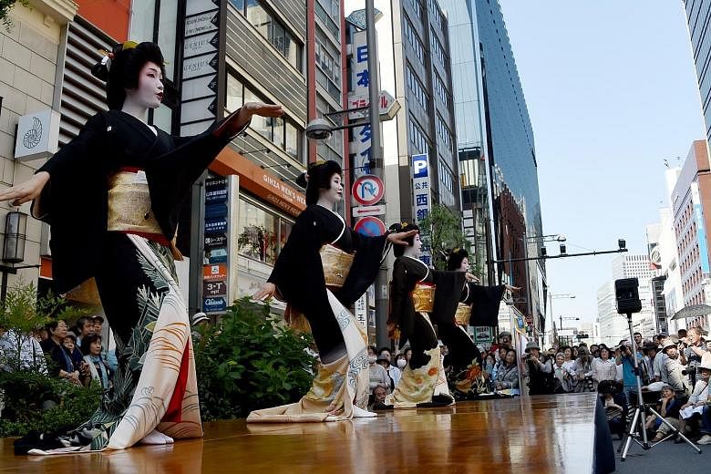 Geishas performing a traditional dance on a stage during the Ginza Yanagi festival at the Ginza shopping district in Tokyo yesterday. Geishas working in the area displayed their skills for holiday shoppers to promote their Azuma Odori, a traditional 