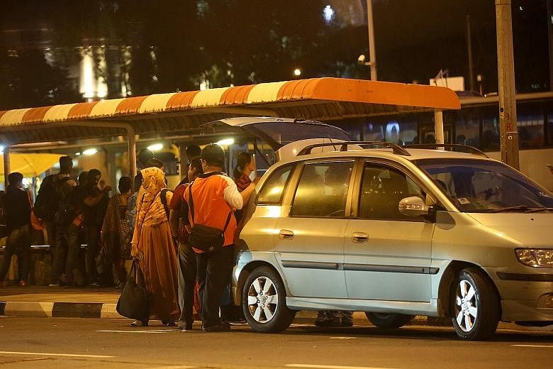 Passengers entering a car offered by a tout near the intersection next to the Ban San Street terminal last Friday. These illegal cross-border taxis charge fees which can range from $10 to $30 per person. A check found at least 20 making use of apps l