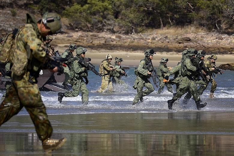 Soldiers from the SAF Guards battalion and the Australian Defence Force's 7th Australian Regiment carrying out a beach landing in the Shoalwater Bay Training Area in 2014, during a preview of Exercise Trident.
