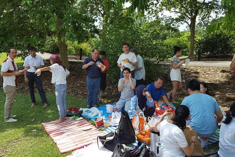 Dr Chee (second from left), having a picnic with Singapore Democratic Party members and volunteers at the Botanic Gardens yesterday afternoon. He spent the rest of the day with his family, said a party spokesman. Mr Murali (third from left) having lu