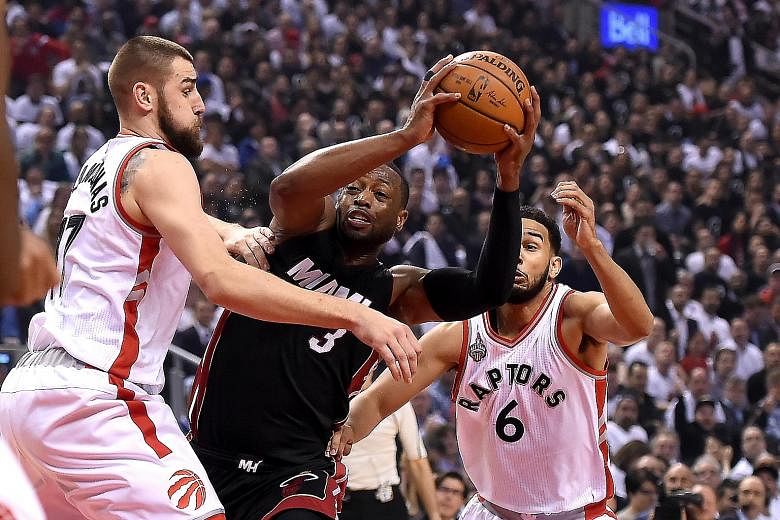 Miami Heat guard Dwyane Wade (centre) being sandwiched by Toronto Raptors centre Jonas Valanciunas (left) and guard Cory Joseph in their NBA play-offs Game 2 clash. Their Eastern Conference semi-final series is tied at 1-1.