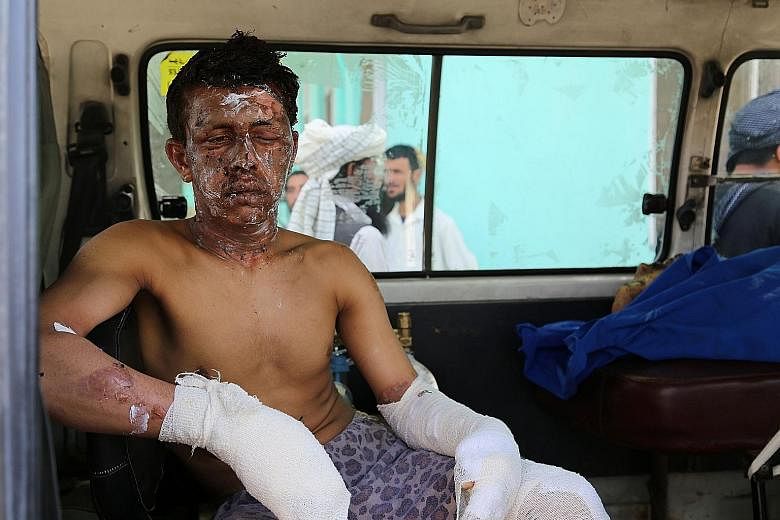 An injured man in an ambulance in Ghazni yesterday, after an oil tanker and two buses collided on the Kabul-Kandahar highway.
