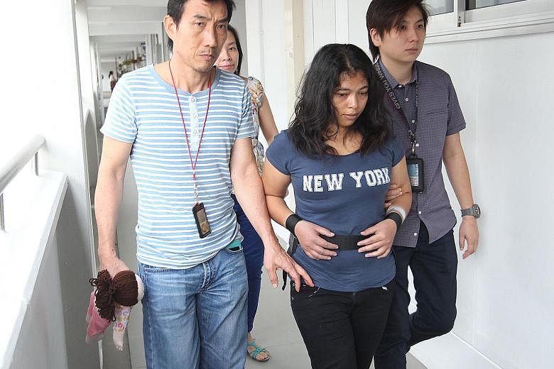Maryani being taken by police to her employer's flat in Simei yesterday. She was out when the toddler was found unconscious on Sunday morning. Police arrested her in the Marina Bay area later that day. Richelle had bruises on her neck and head, and h